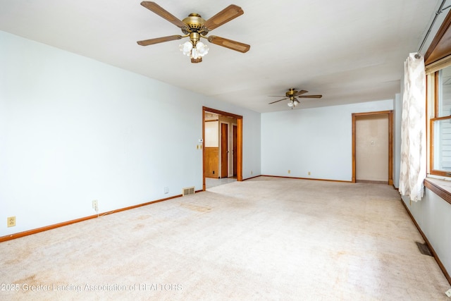 empty room featuring visible vents, light carpet, and baseboards