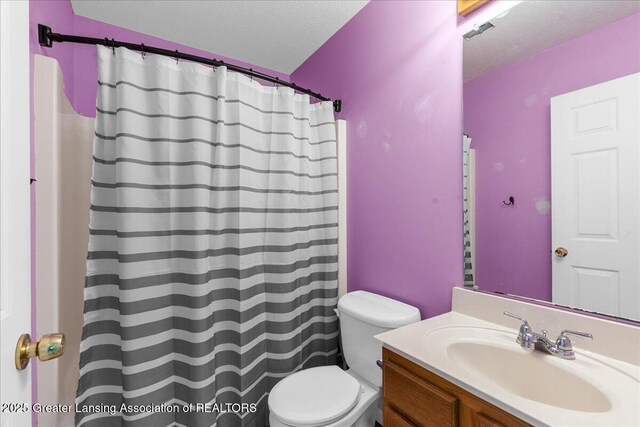 bathroom featuring toilet, a textured ceiling, vanity, and a shower with curtain