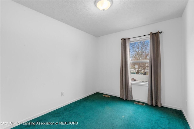 carpeted empty room with visible vents, a textured ceiling, and baseboards