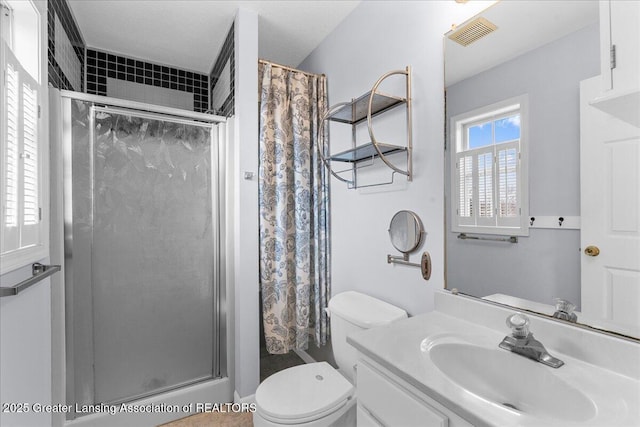 full bathroom featuring visible vents, toilet, a stall shower, and vanity