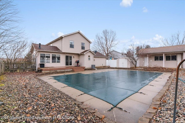 view of swimming pool with an outdoor structure, a storage unit, fence, and a fenced in pool