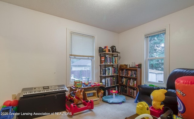 rec room featuring carpet floors and a textured ceiling