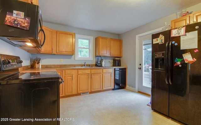 kitchen featuring visible vents, black appliances, a sink, baseboards, and light floors