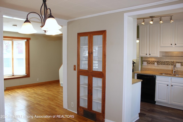 kitchen featuring dark wood-style flooring, a sink, dishwasher, crown molding, and backsplash