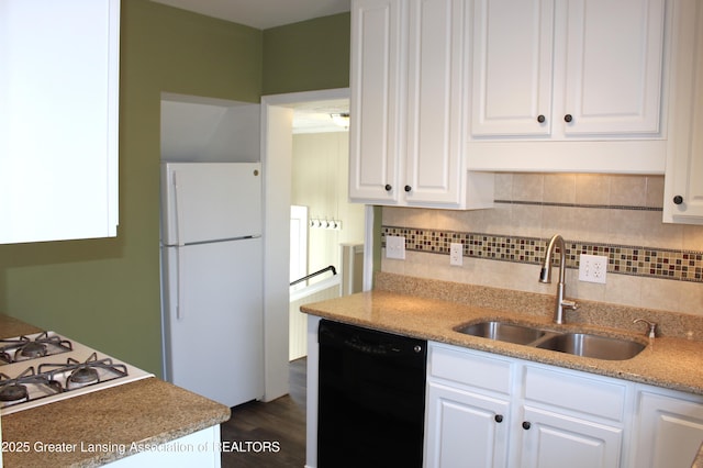 kitchen featuring tasteful backsplash, dishwasher, freestanding refrigerator, white cabinets, and a sink