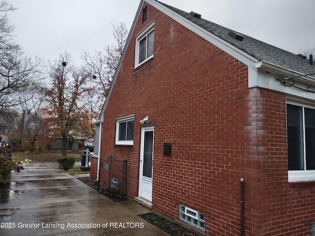 view of side of home with brick siding and driveway