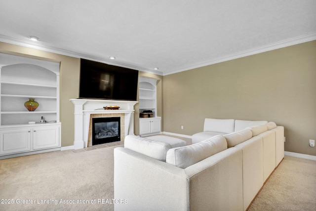 living room with light carpet, ornamental molding, a tiled fireplace, built in features, and baseboards