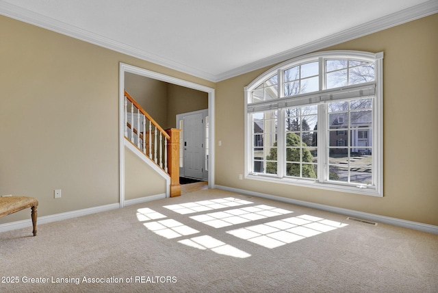 interior space with carpet flooring, baseboards, visible vents, and ornamental molding