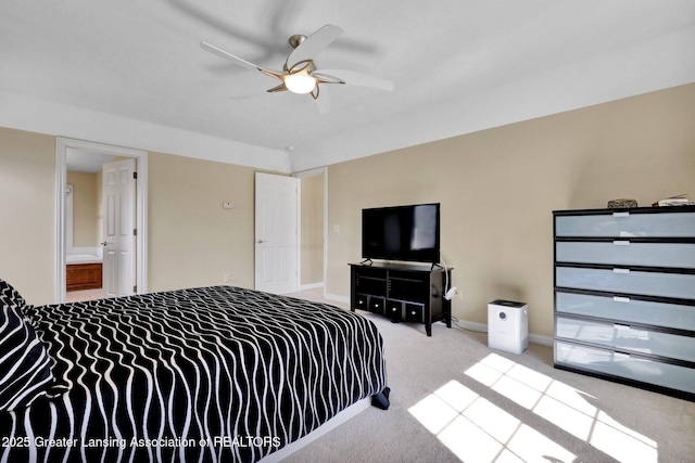 carpeted bedroom featuring baseboards, ensuite bathroom, and a ceiling fan