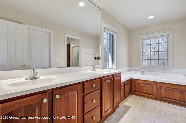 full bathroom with a healthy amount of sunlight, a garden tub, and a sink