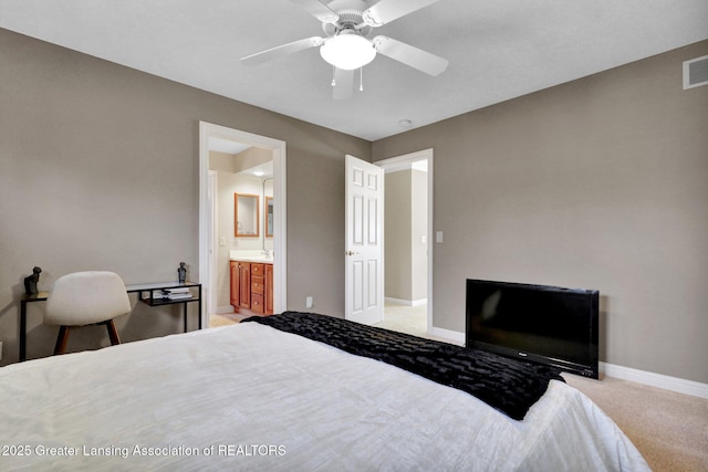 bedroom with a ceiling fan, visible vents, baseboards, ensuite bath, and light carpet