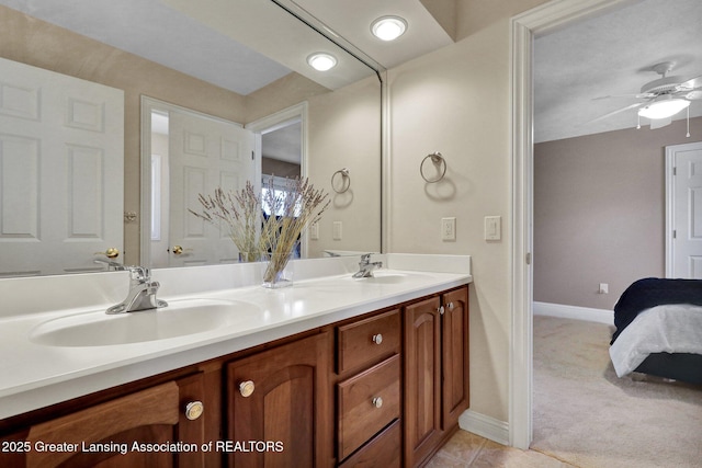 bathroom featuring a sink, baseboards, ceiling fan, and double vanity