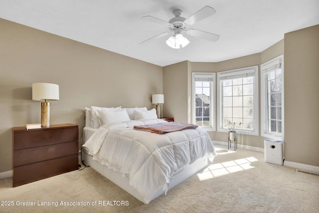 carpeted bedroom with baseboards, visible vents, and ceiling fan