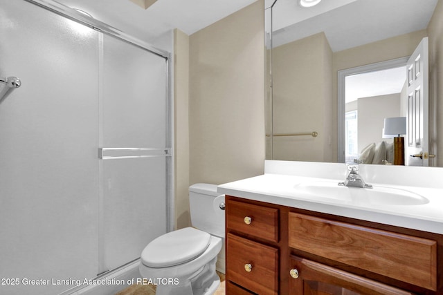 bathroom with vanity, toilet, and a shower stall