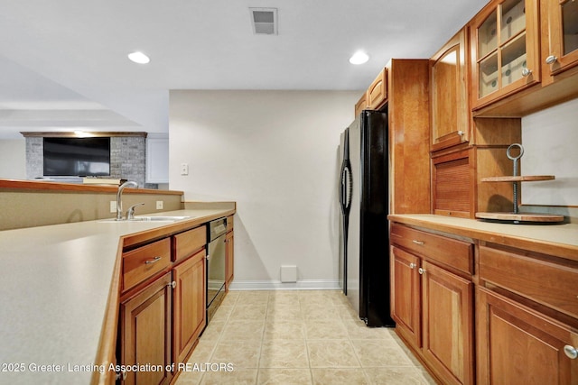 kitchen featuring visible vents, freestanding refrigerator, a sink, light countertops, and dishwasher