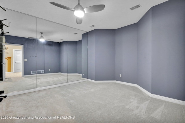 spare room featuring visible vents, ceiling fan, and carpet flooring