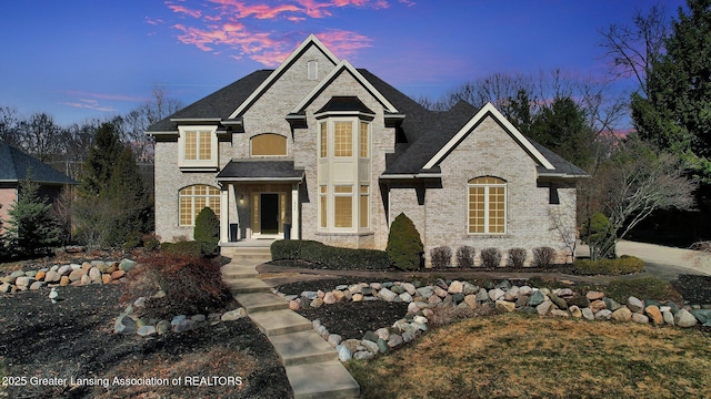 french provincial home with brick siding