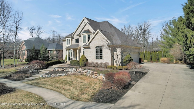 view of front of house featuring concrete driveway, an attached garage, and brick siding