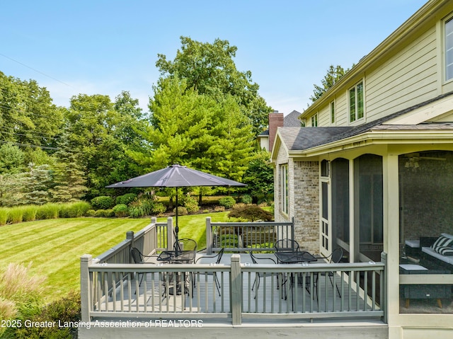 deck featuring outdoor dining space and a yard