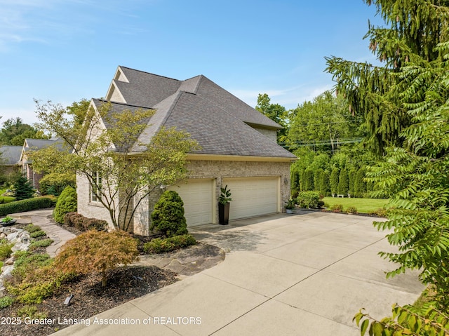 view of home's exterior featuring brick siding, a garage, driveway, and roof with shingles