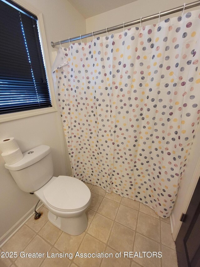 full bathroom featuring tile patterned floors, toilet, and a shower with shower curtain