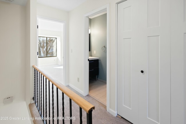 hallway with light carpet and baseboards