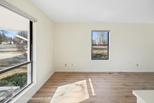 empty room with baseboards and wood finished floors