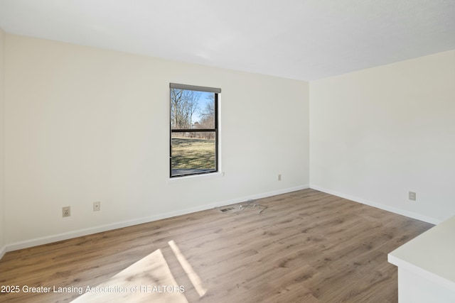 empty room featuring baseboards and wood finished floors