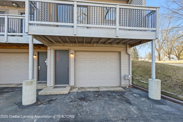 property entrance featuring an attached garage and driveway