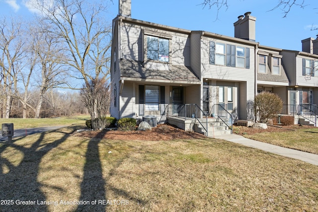 view of front of home with central AC, covered porch, a chimney, and a front lawn