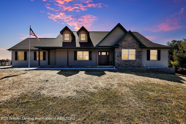 view of front of property featuring a yard and stone siding