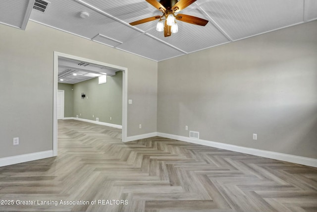 unfurnished room featuring visible vents, a ceiling fan, and baseboards