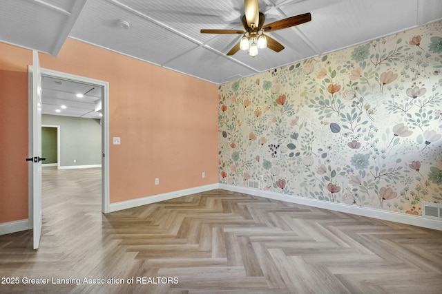 empty room featuring visible vents, ceiling fan, and baseboards