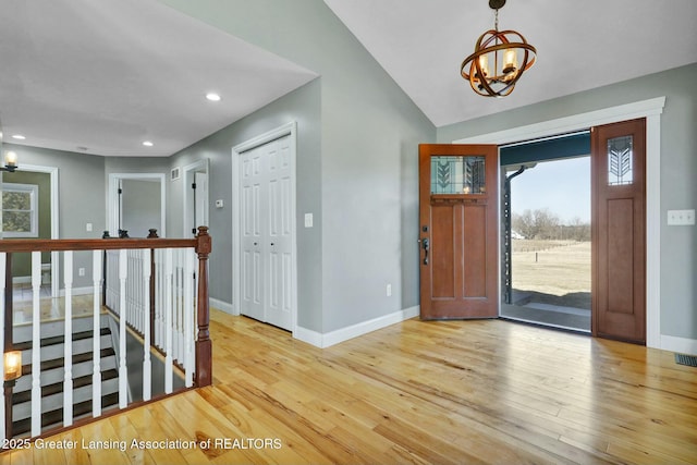 foyer entrance with recessed lighting, baseboards, wood-type flooring, and a chandelier