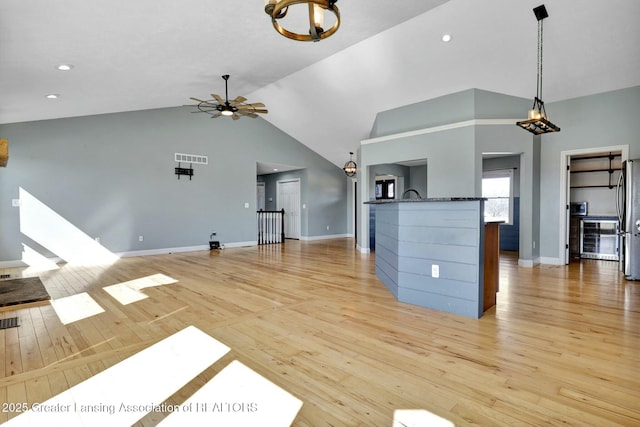 unfurnished living room with visible vents, baseboards, light wood-style flooring, and a ceiling fan