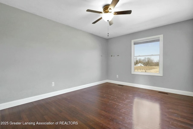 empty room featuring visible vents, wood finished floors, baseboards, and ceiling fan