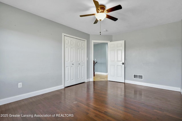 unfurnished bedroom with a closet, visible vents, baseboards, and hardwood / wood-style floors