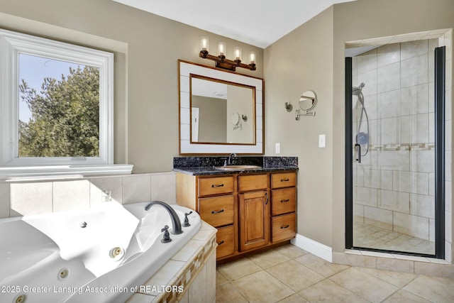 bathroom with tile patterned floors, a stall shower, a tub with jets, baseboards, and vanity