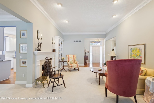 living area with visible vents, baseboards, a lit fireplace, and ornamental molding