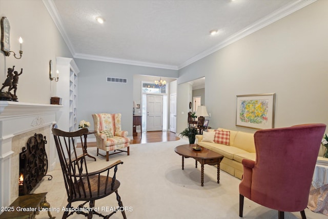 living area with baseboards, visible vents, a premium fireplace, ornamental molding, and a chandelier