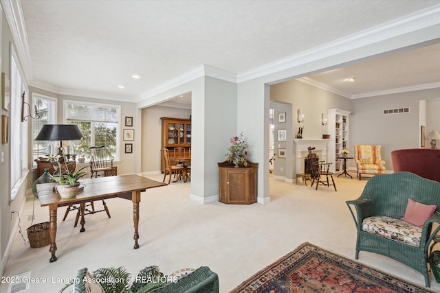 carpeted office space with visible vents, recessed lighting, a fireplace, crown molding, and baseboards