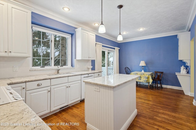 kitchen with dark wood-style floors, white dishwasher, a sink, white cabinets, and crown molding