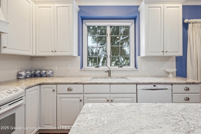 kitchen featuring tasteful backsplash, white appliances, white cabinetry, and a sink