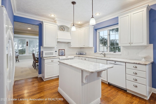 kitchen with white appliances, plenty of natural light, and white cabinets