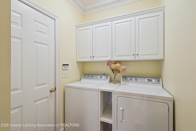 laundry room featuring cabinet space, separate washer and dryer, and crown molding