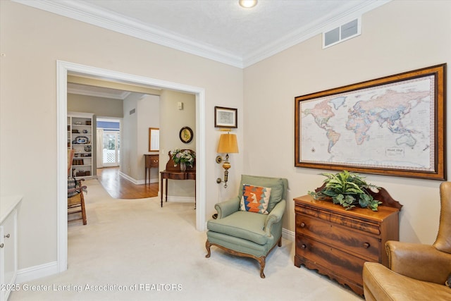 living area featuring crown molding, light colored carpet, visible vents, and baseboards