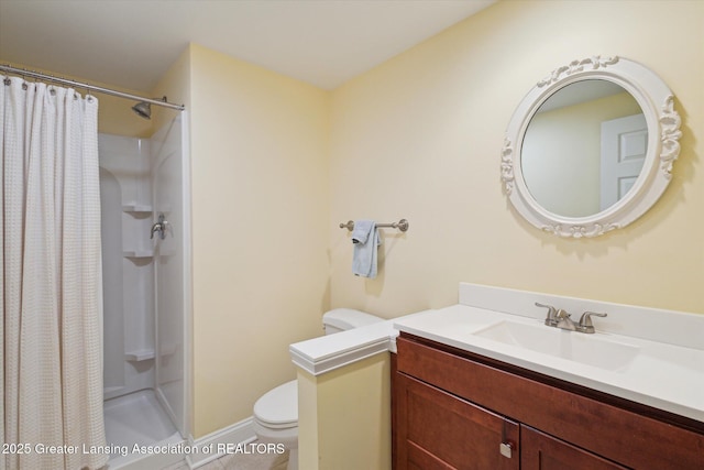 full bath featuring a stall shower, toilet, and vanity