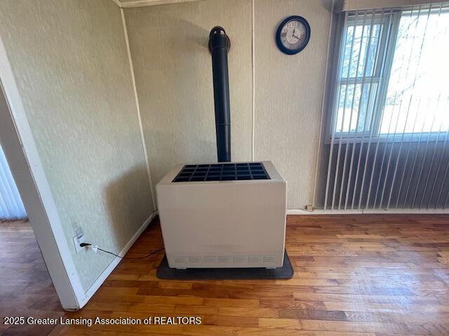 interior details with a wood stove and wood finished floors