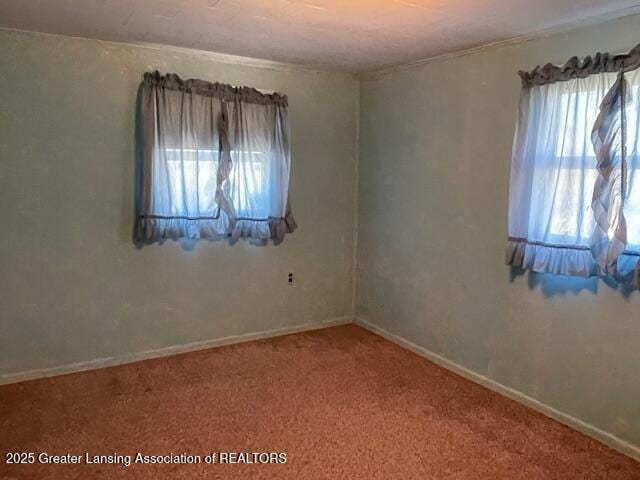 empty room featuring baseboards and carpet floors