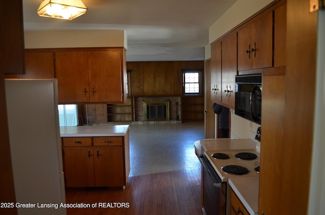 kitchen with brown cabinetry, light countertops, black microwave, and white electric range oven